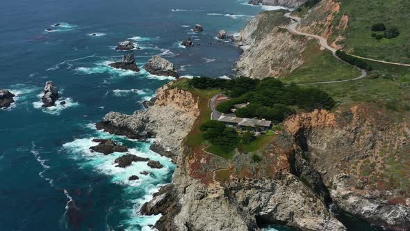Aerial drone circling the rocky stretch of coastal road in Big Sur California alongside Route 1 duri alt