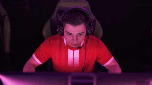 Portrait of a Focused Gamer in Headphones Plays a Video Game Cyber Sportsman Communicates with the alt