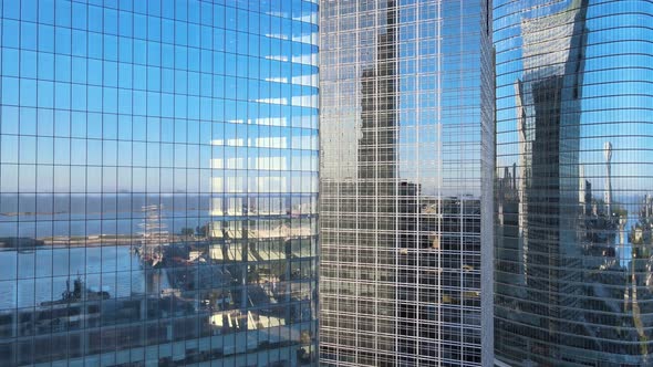 Aerial dolly out of window glass skyscrapers mirroring Puerto Madero docks at golden hour, Buenos Ai alt