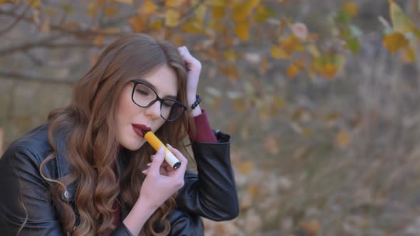 Beautiful Girl Smokes an Electronic Cigarette alt