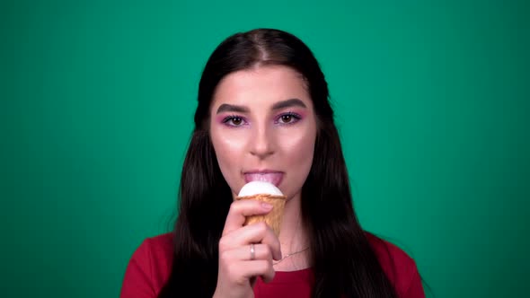 Young Woman Eating White Ice Cream Enjoying Sweets Isolated on Blue Background