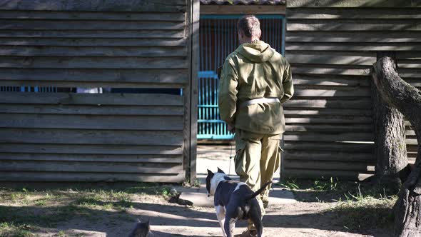 Caucasian Man Holding Dog Collar Walking with American Staffordshire Terrier to Dog Training Center alt