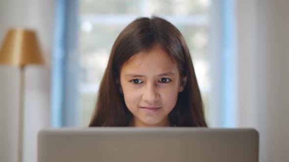 Schoolgirl Learning and Looking at Laptop Computer Doing Homework alt