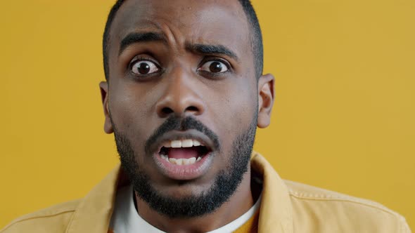 Closeup Portrait of Shocked African American Man Staring at Camera with Confusion alt