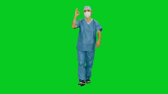 Doctor In Mask And Uniform Walking In Hallway Of Hospital And Showing Ok Sign