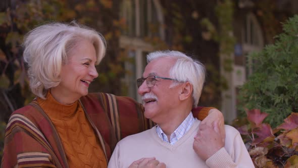 Handsome senior couple embracing in autumn park