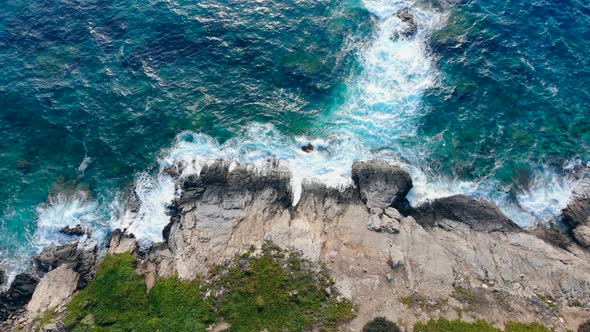 Ocean Waves Are Slowly Crashing Along the Rocks alt