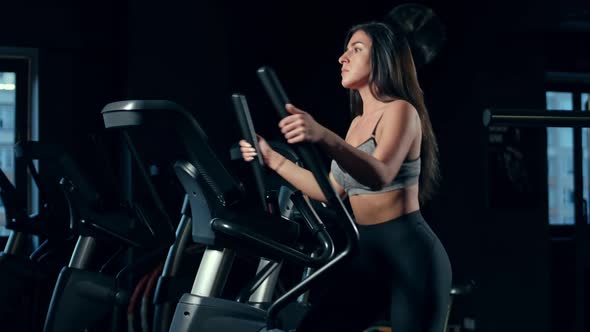 Woman running on the Elliptical at sport saloon