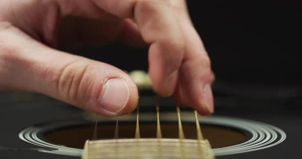 Extreme close up of fingers strumming strings alt
