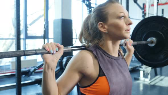 Fit Woman Doing Weight Lifting Exercises in Gym. Woman Training Squat Strength With Heavy Weights alt
