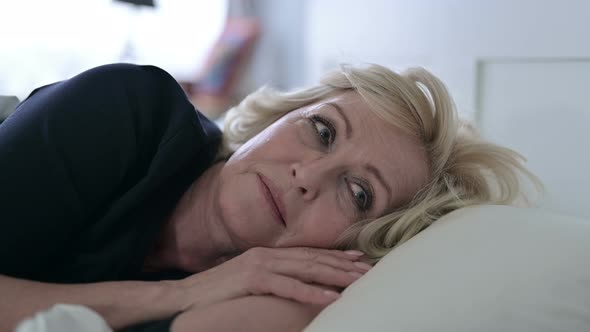 worried-old-woman-thinking-while-sleeping-in-bed-stock-footage-videohive