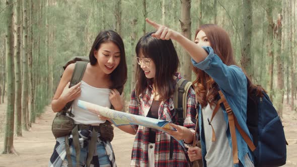 Asian hiker women trekking in forest. Young happy backpack girls walking enjoy her journey.