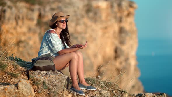 Beautiful Smiling Hiker Female Relaxing on Top of Mountain Enjoying Natural View at Sunset alt
