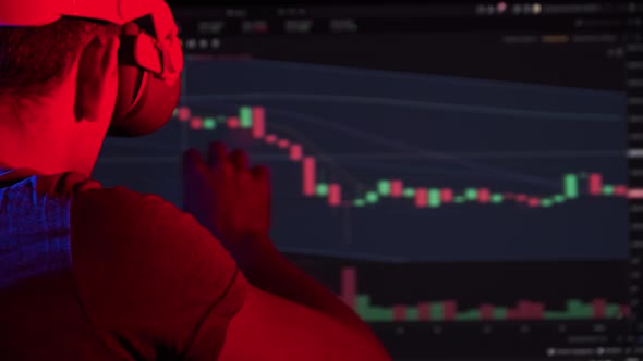 Trader in a Virtual Reality Helmet Looks at Cryptocurrency Charts alt