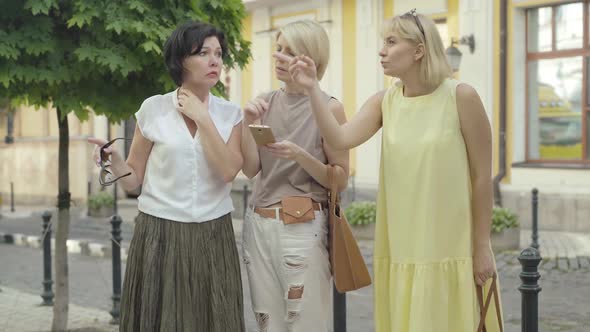 Confused Mid-adult Female Tourists Using Online Map To Choose the Direction in Foreign City alt