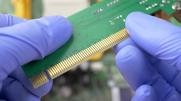 Hand in Blue Gloves Holds PCI Express Card for Computer alt