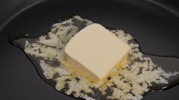 Stick of Butter Melting in Hot Black Frying Pan  Close Up Timelapse