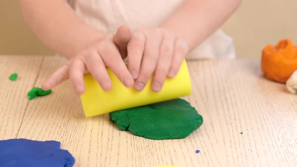 Close up of kids hands molding colorful childs play clay.