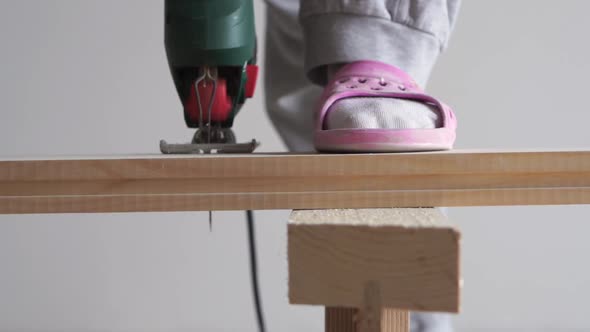 Beauty of Slow Motion in Construction and Repair - Man Sawing a Wooden Board with an Electric Jigsaw
