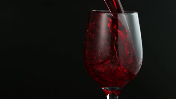 Pouring Red Wine in Super Slow Motion on Black Background alt