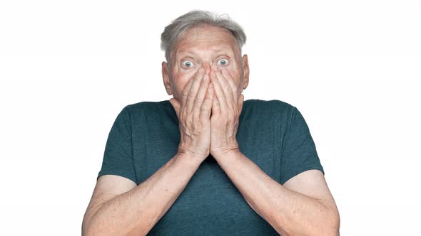 Portrait of Impressed Old Aged Man 70s Having Gray Hair in Basic Tshirt Covering Face in Surprise alt
