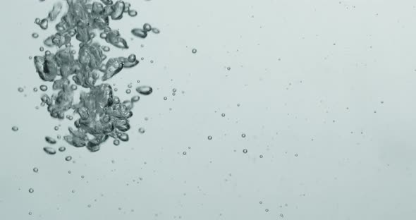 Liquid Being Poured Into Water Creating Rising Bubbles alt