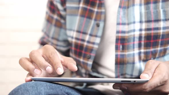 Work From Home Concept Young Man Sitting on Floor Working on Digital Tablet alt
