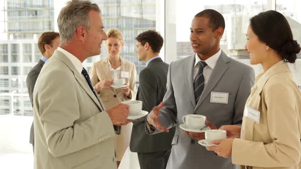 Business people chatting at a conference having coffee alt