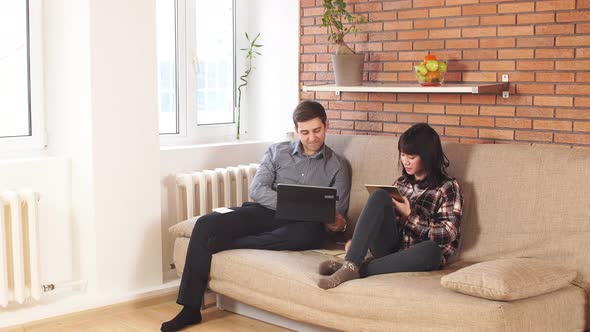 Young Business Couple Using Laptop at Home.
