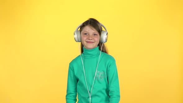 Сute Girl Listening To Music in Big White Headphones alt