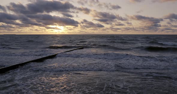 Breakwater of Larch Logs. Strengthening the Seashore To Keep the Sand on the Beach. Gorgeous Sunset
