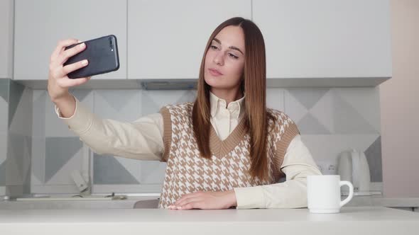 The Girl Poses on the Phone Camera Takes a Selfie alt