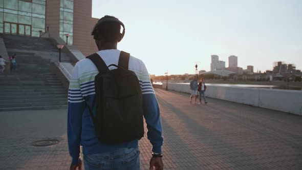 Black Student Walks Around Town at Sunset He's Happy
