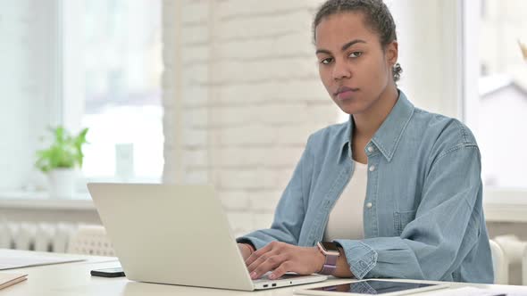 Young African Woman Working and Showing Thumbs Down alt