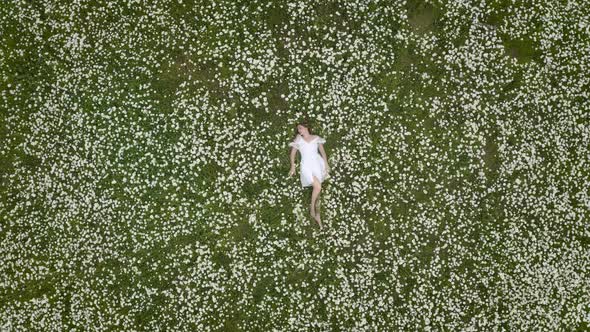 Beautiful Girl Lies in Camomile Daisy Flower