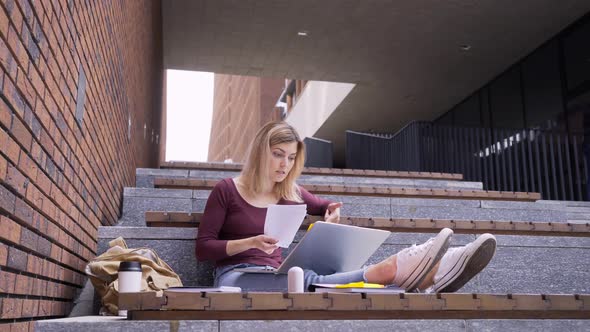 Female with Backpack Has Online Conference in Park