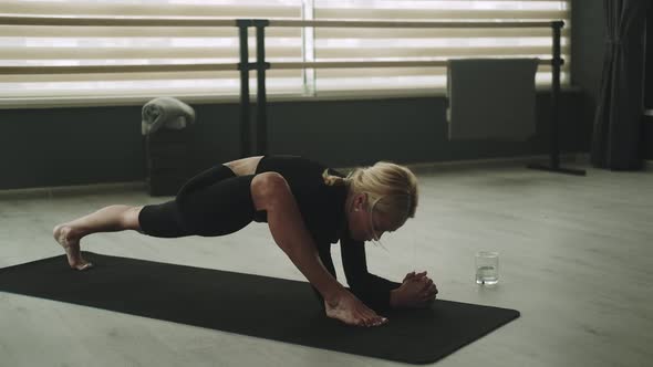 Woman in Sportswear on Mat Stretching to Sides
