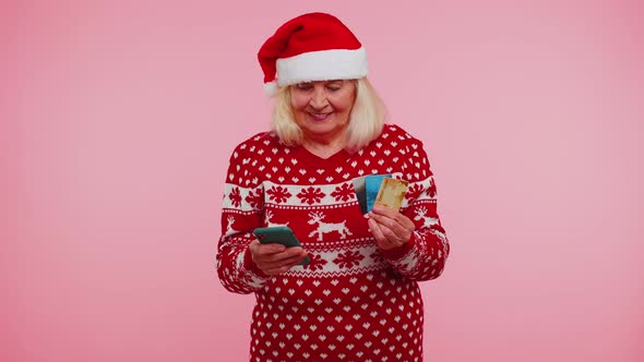 Christmas Grandmother Using Credit Bank Card Smartphone While Transferring Money Shopping Online alt
