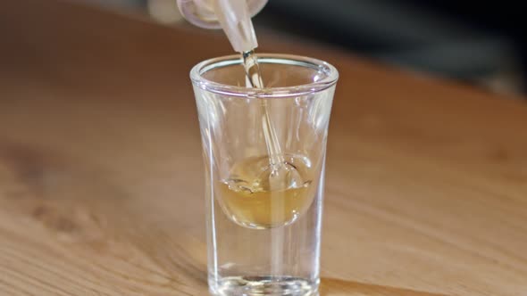Slow motion of a whiskey shot poured into a glass