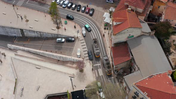 Two Tram Cars Passing By Each Other in Narrow Town Street alt