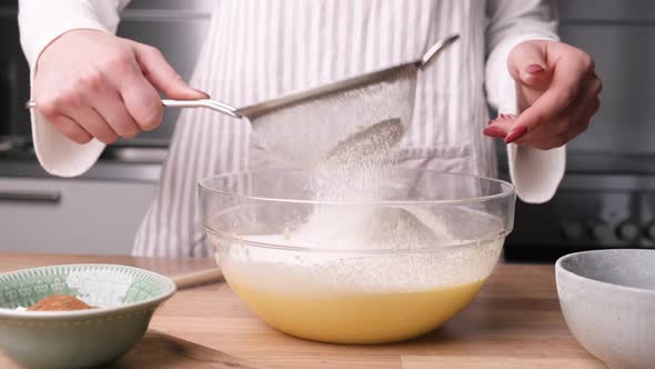 Female Hands Sift Flour into Bowl for Cake Batter. - Slider Left alt
