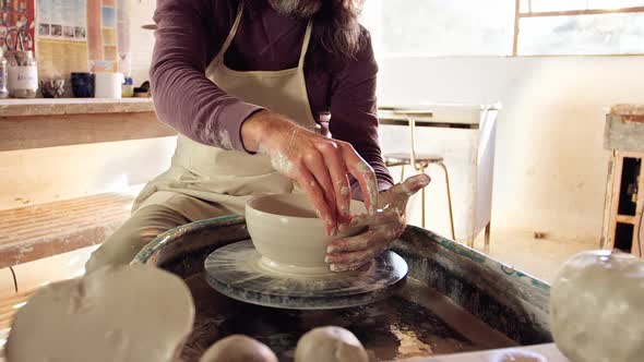 Male potter making pot alt
