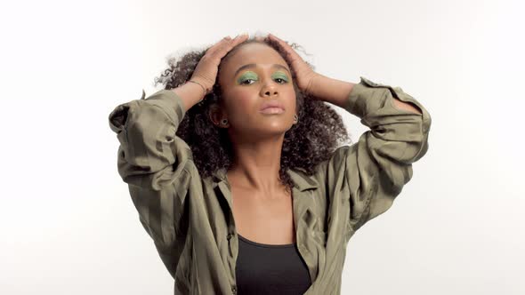 Young Mixed Race Model in Studio on White with Curly Hair, Bright Green Eye Makeup