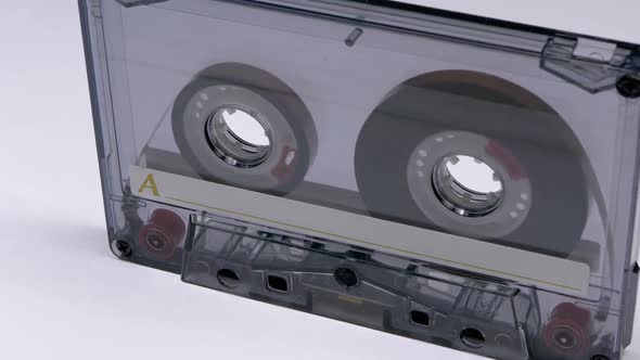 Vintage Transparent Audio Cassette Rotates on White Background alt