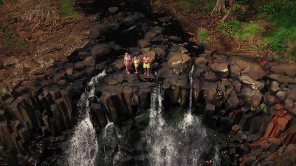 A Family in the Background of the Rochester Waterfall on the Island of Mauritius in the Jungle