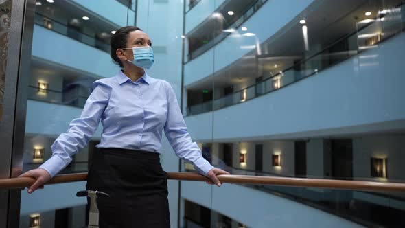 Masked Mixed Race Woman Going Down Elevator alt