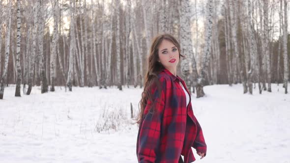 Female in Checkered Shirt Walking in Snowy Park