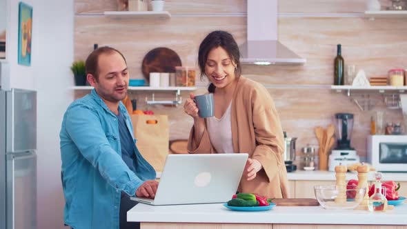 Entrepreneur Working on Laptop in Kitchen alt