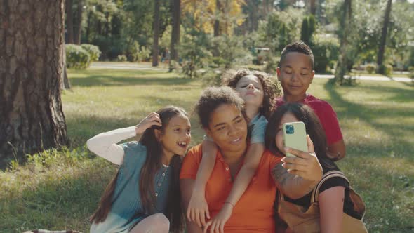 Elementary Students and School Teacher Photographing in Public Park alt