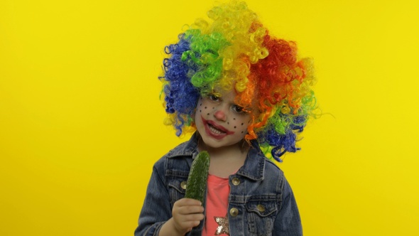 Little Child Girl Clown in Colorful Wig Making Silly Faces, Singing, Smiling, Dancing. Halloween alt